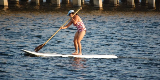 mujer practicando paddle surf en una tabla blanca.jpg